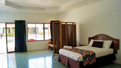 a bedroom with a bed and a large window at Hotel Costa Pacifica in Esterillos