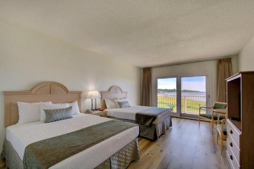a hotel room with two beds and a balcony at Epworth By The Sea in Saint Simons Island