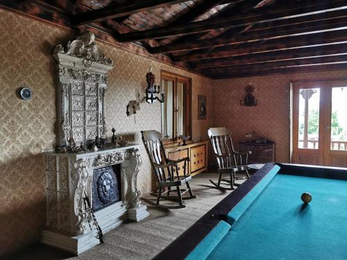 a living room with a pool table and a fireplace at Guest House Top Floor in Tʼelavi