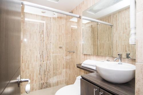 uma casa de banho com um lavatório e um chuveiro em Stay Blue Hotel em Bogotá