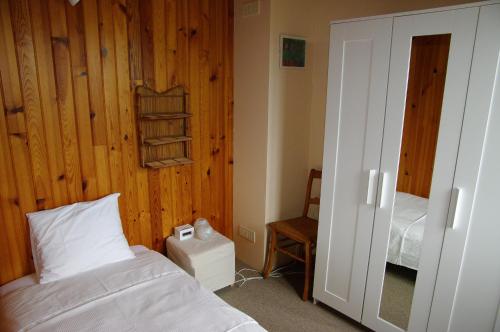 1 dormitorio con 1 cama y pared de madera en Le Cers, en Ribaute