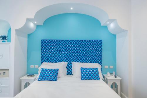 a blue bedroom with a bed with a blue headboard at Tramonto d'Oro in Praiano