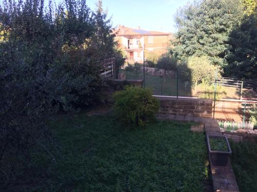 a garden with a fence and a house in the background at CASETTA RELAX A SUTRI in Sutri