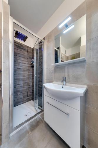 une salle de bain avec un lavabo blanc et une douche dans l'établissement Studio la Plage, à Roquebrune-Cap-Martin