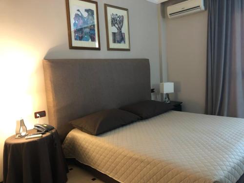 a bedroom with a bed and two pictures on the wall at Domizia Palace Hotel in Baia Domizia