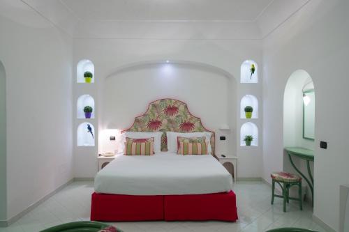 a bedroom with a large bed with a red headboard at Tramonto d'Oro in Praiano