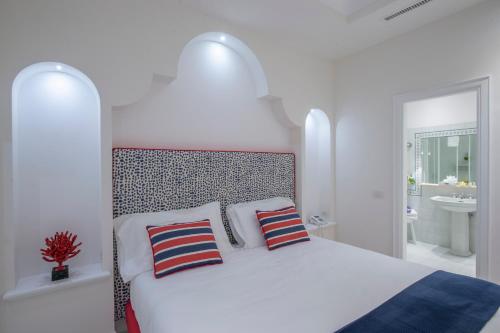 a white bedroom with a bed with two pillows at Tramonto d'Oro in Praiano
