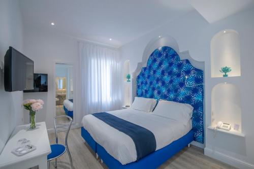 a bedroom with a blue bed with a blue headboard at Tramonto d'Oro in Praiano
