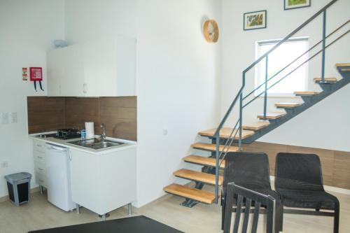 une cuisine avec deux chaises et un escalier dans une maison dans l'établissement Casa das Pipas #1, à Pinhal Novo