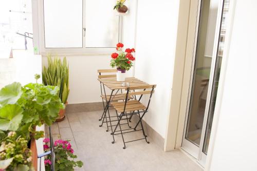 einen kleinen Balkon mit einem Tisch mit Blumen darauf in der Unterkunft B&B d'Orleans in Palermo