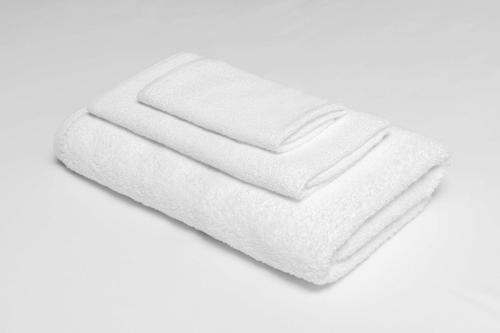 une pile de serviettes blanches sur fond blanc dans l'établissement Castle Inn & Suites Anadarko, à Anadarko