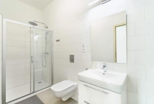 a white bathroom with a sink and a shower at Pilsner Apartments - U Matky Boží in Pilsen