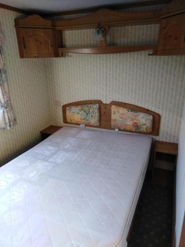 1 dormitorio con 1 cama blanca en una habitación en Vinařský mobilheim, en Vrbovec