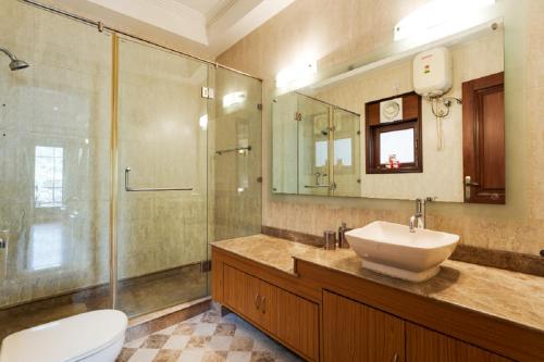 a bathroom with a sink and a shower and a toilet at Hostie - 4BHK Apartment with lift near Greater Kailash, South Delhi in New Delhi