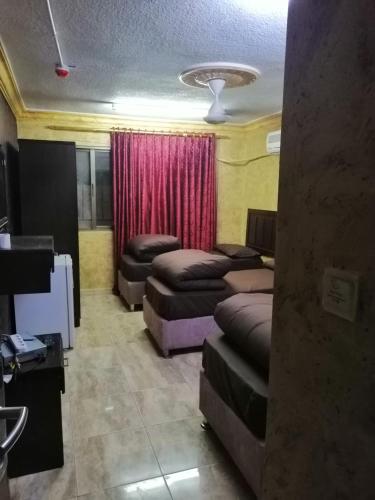 a room with three beds and a red curtain at Aqaba Roza in Aqaba