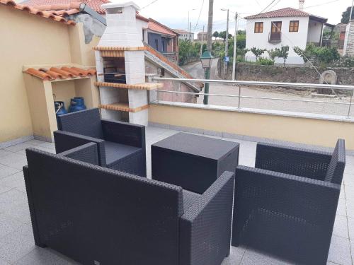 a balcony with black furniture on a building at Casa do Ti Correia in Macedo de Cavaleiros
