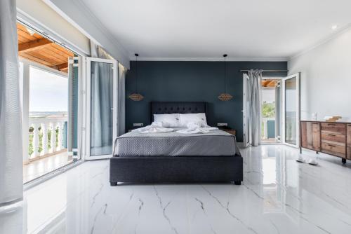 a bedroom with a large bed and large windows at Zante Calinica Hotel in Tsilivi