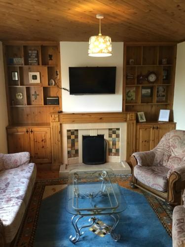 a living room with a fireplace and a tv at St Judes House in Killarney