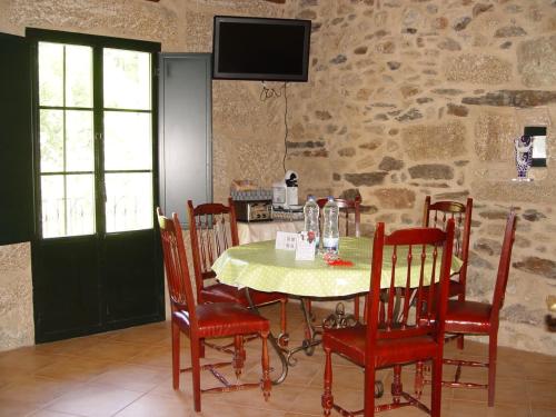 jadalnia ze stołem z krzesłami i telewizorem w obiekcie Casa en Viñoas (Ribeira Sacra) w mieście Viñoás