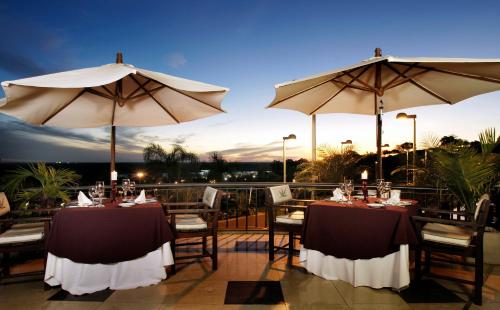 two tables and two umbrellas on a patio at Sol Victoria Hotel SPA & Casino in Victoria