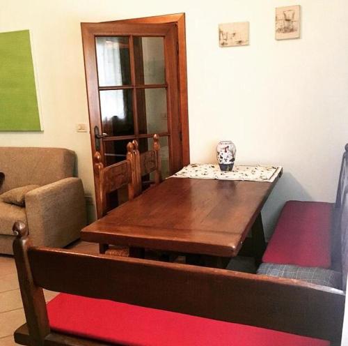 a dining room with a wooden table and a chair at Da Scilla in Punta Marina