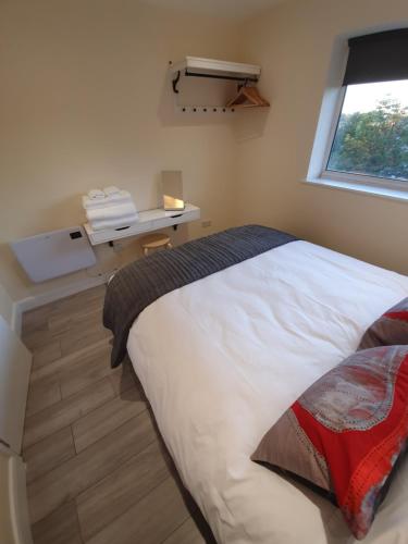 a bedroom with a white bed and a window at Luxurious Luton town center flat with free parking in Luton
