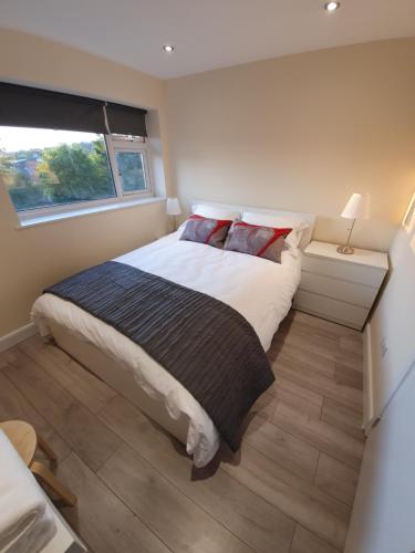 a bedroom with a bed and a window at Luxurious Luton town center flat with free parking in Luton