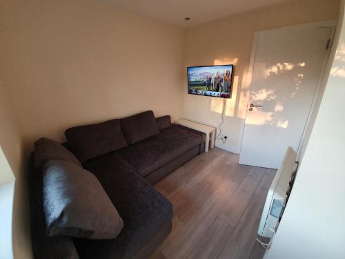 a living room with a couch and a flat screen tv at Luxurious Luton town center flat with free parking in Luton