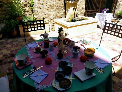 a table with a purple table cloth with food on it at Le Térébinthe B&B in Lauris