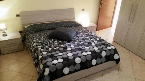 sypialnia z łóżkiem z czarno-białą kołdrą w obiekcie New Apartment Lake View 11 w mieście Varenna