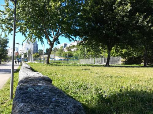 a stone wall in a park with trees and grass at Green Villas Douro in Gondomar