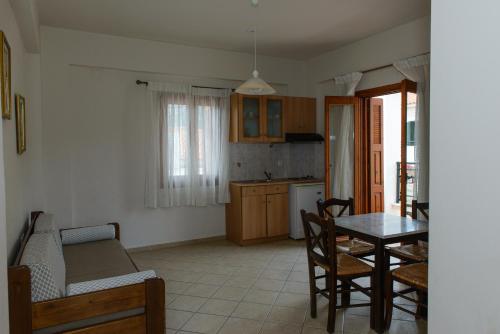 a kitchen and dining room with a table and chairs at So Nice Hotel in Marathokampos