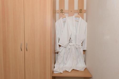 a white robe hanging on a rack in a closet at So Nice Hotel in Marathokampos