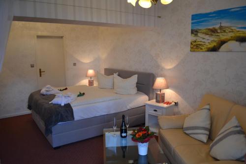 a hotel room with a bed and a couch at Hotel Hansa in Wenningstedt
