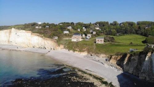 - une vue aérienne sur une plage avec des maisons sur une falaise dans l'établissement Studiomer Résidence pleine mer, à Saint-Pierre-en-Port