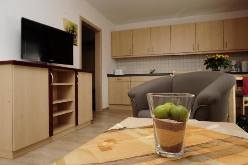 a living room with a table with a glass of fruit at Ferienappartements Am Spreewaldfliess in Schlepzig