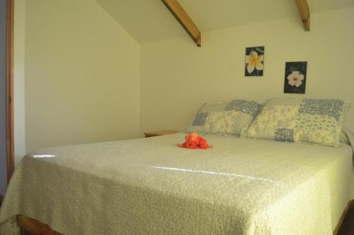 a bedroom with a bed with an orange flower on it at Cabaña Manuto Tahai in Hanga Roa