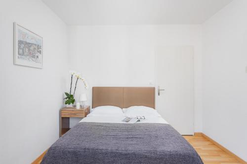 a bedroom with a bed with a gray blanket at Swiss Star Aussersihl - Self Check-In in Zürich