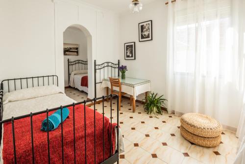 1 dormitorio con 1 cama, 1 mesa y 1 cama sidx sidx sidx sidx en Apartamento Triana Los Remedios, en Sevilla