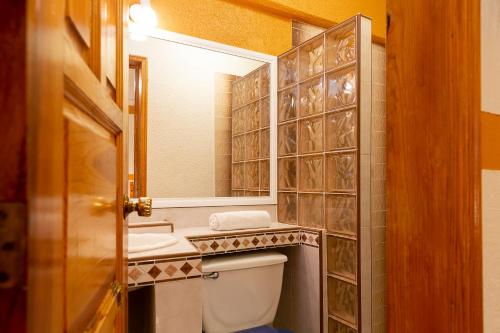 een badkamer met een toilet, een wastafel en een spiegel bij Casablanca Hotel Tula in Tula de Allende