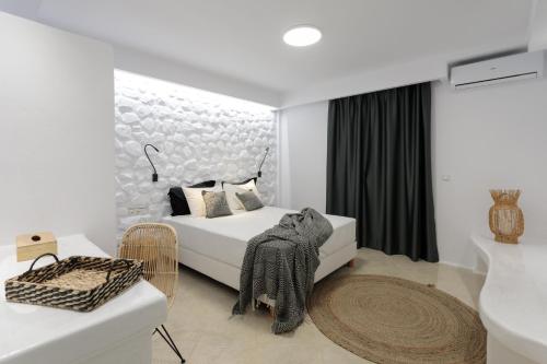 a white bedroom with a bed and a table at Iphimedeia Luxury Hotel & Suites in Naxos Chora