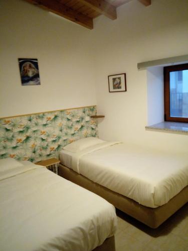a bedroom with two beds and a window at O Nosso Lar in Lagos