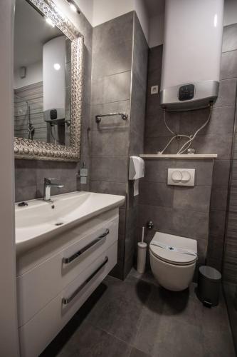 a bathroom with a sink and a toilet and a mirror at Center Luxury Rooms 3 in Split
