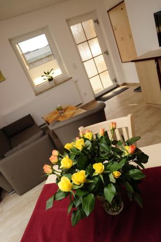 a vase of flowers on a table in a living room at Ferienappartements Am Spreewaldfliess in Schlepzig