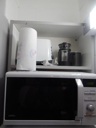 Un rollo de toallas de papel encima de un microondas. en Apio Studio Centro, en Buenos Aires