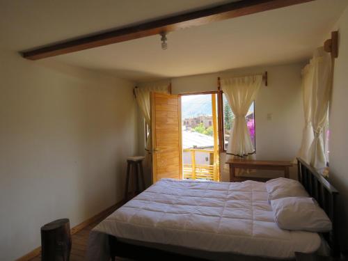 a bedroom with a bed and a large window at Schatzi Lodge in Huaraz