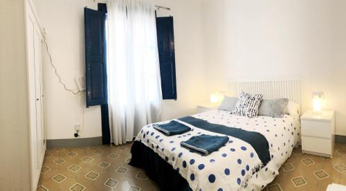 een slaapkamer met een bed met blauwe handdoeken bij Casita de Pescador in Calafell