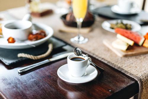 a table topped with a cup of coffee and food at Almond Beach Resort at Jaguar Reef in Hopkins