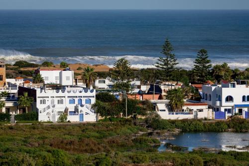 a small town with white houses and the ocean at Surf And Soul Morocco in Oualidia