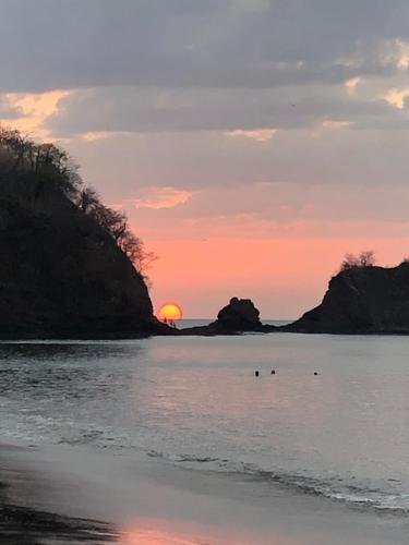 a sunset on the beach with the sun setting at Punta Leona Beach Condos in Jacó